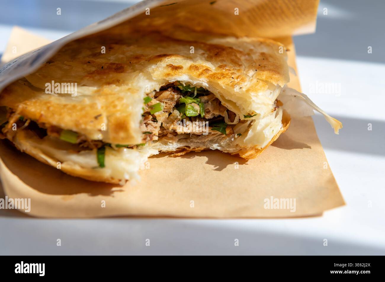 Primo piano di un Roujiamo o hamburger cinese della provincia di Shannxi, Cina. Il panino è un pane piatto croccante a più strati, con il classico ripieno di Foto Stock