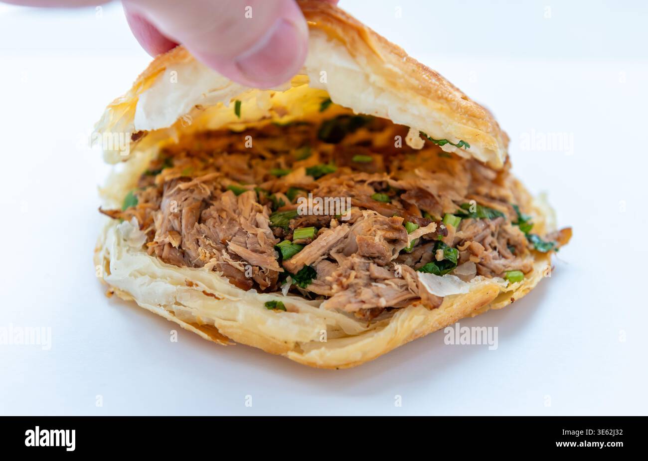 Primo piano di un Roujiamo o hamburger cinese della provincia di Shannxi, Cina. Il panino è un pane piatto croccante a più strati, con il classico ripieno di Foto Stock