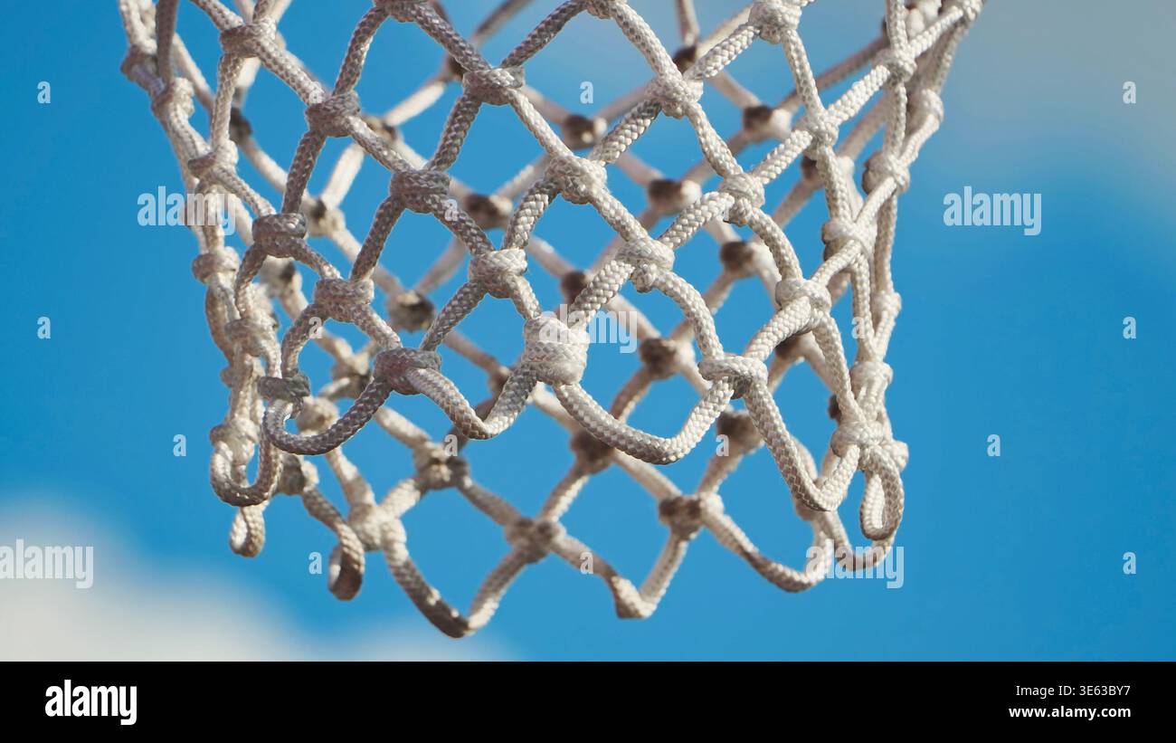 Primo piano di una rete da basket all'aperto contro un cielo blu brillante Foto Stock