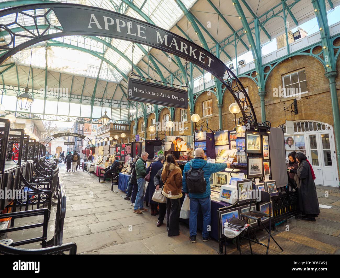 Persone che fanno shopping presso le bancarelle d'arte e di artigianato dell'Apple Market di Covent Garden, Londra, Regno Unito Foto Stock