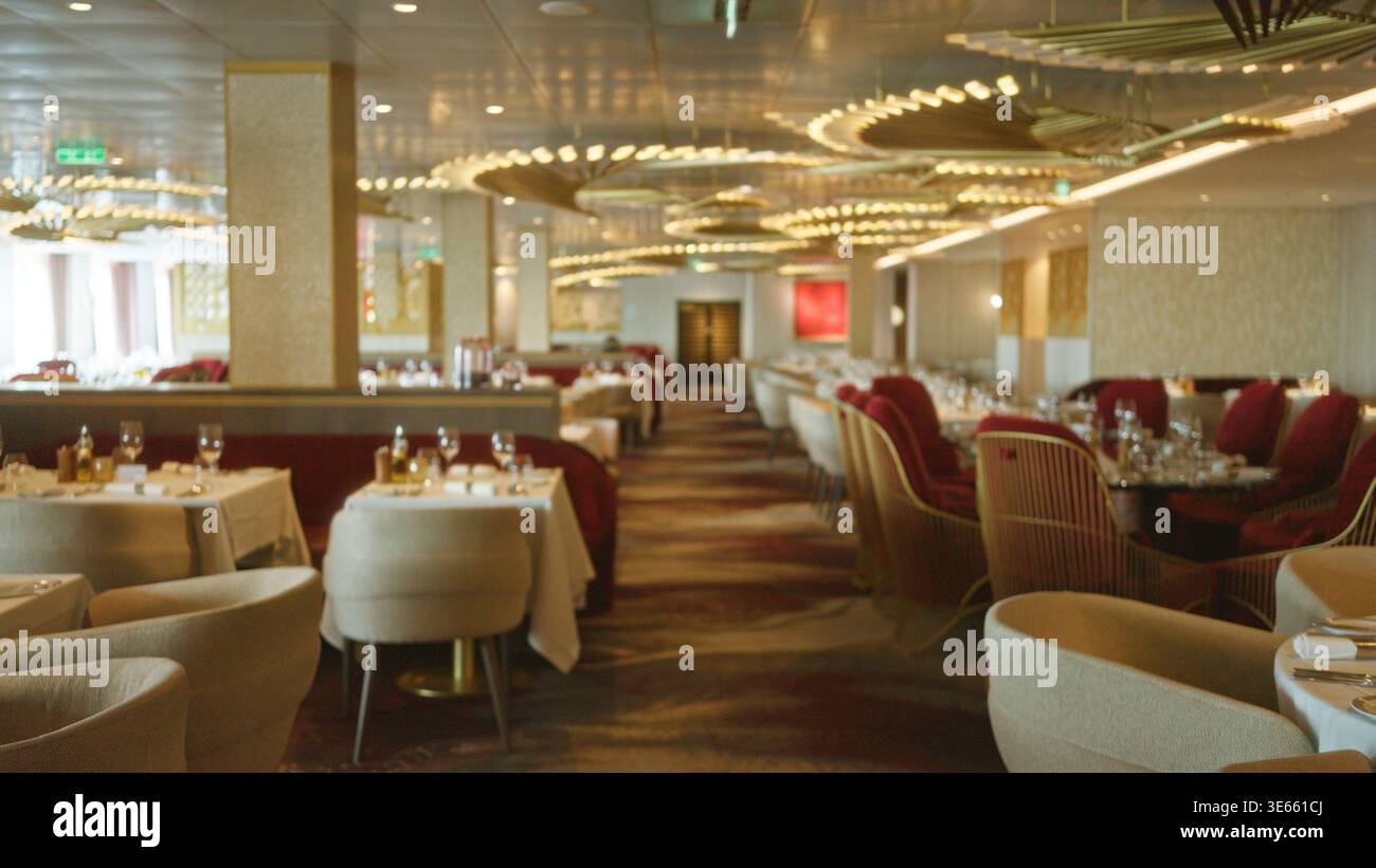 Interni sfocati con soffice bokeh, bassa concentrazione su tavoli e plafoniere in un elegante ristorante interno; sfondo copyspace c Foto Stock