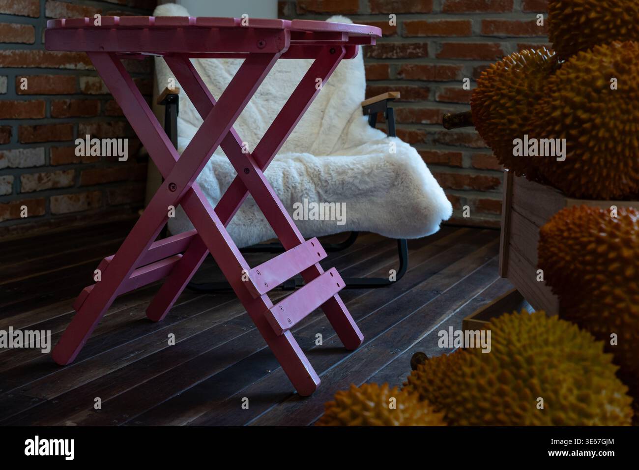 Tavolo pieghevole rosa con poltrona e frutta Durian all'interno Foto Stock