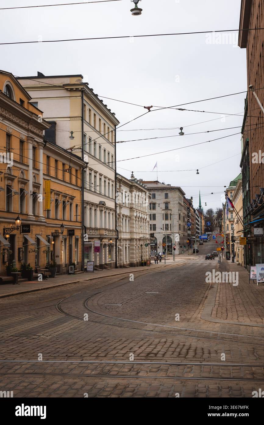 Helsinki, Finlandia. Il centro di Helsinki, circondato da pedoni e da diverse architetture. Ci sono nuvole nel cielo e luce soffusa della sera Foto Stock