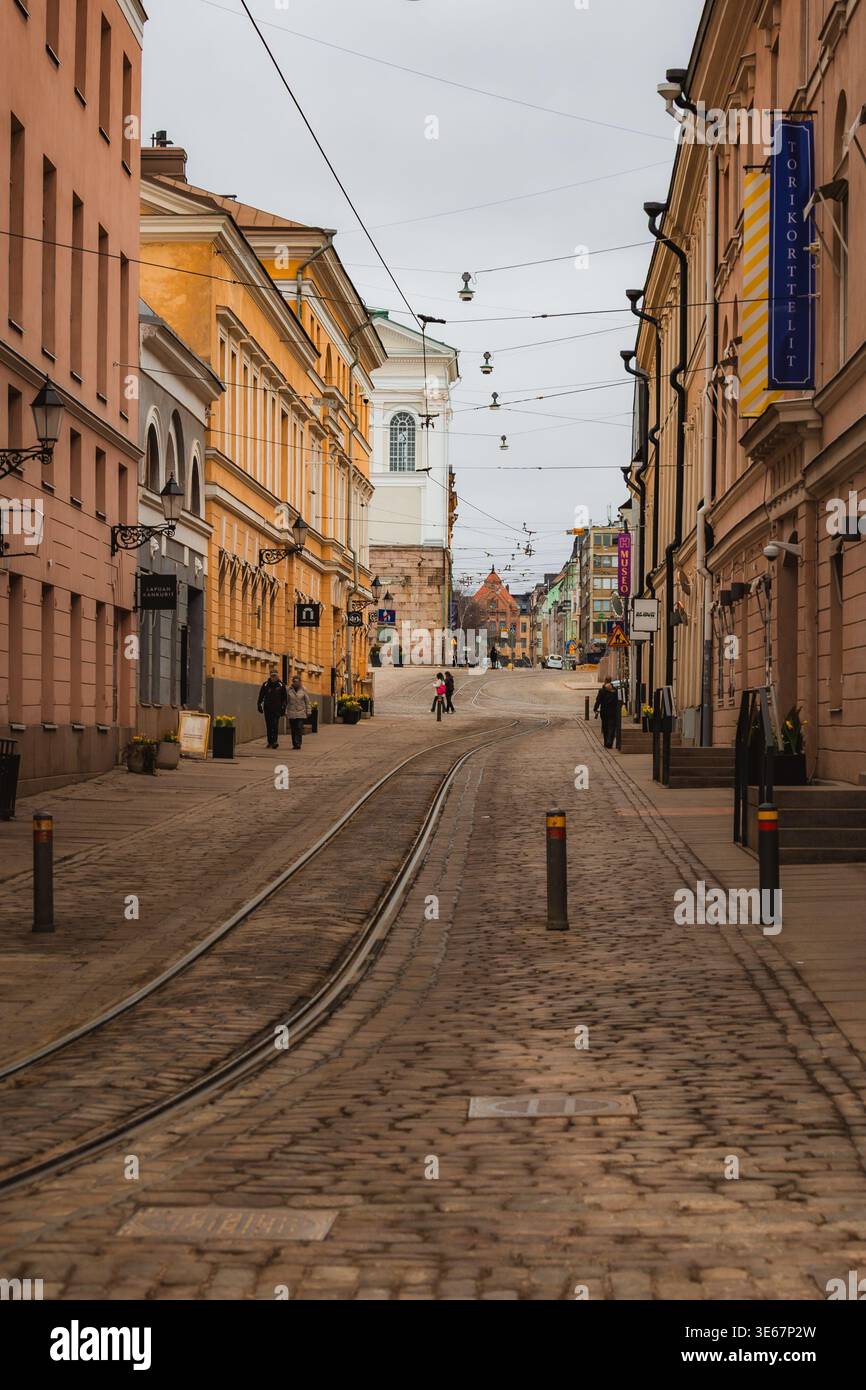 Helsinki, Finlandia. Il centro di Helsinki, circondato da pedoni e da diverse architetture. Ci sono nuvole nel cielo e luce soffusa della sera. Foto Stock