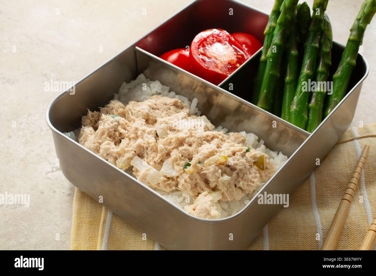 Vista di una scatola bento, con insalata di tonno, pomodoro e asparagi. Foto Stock