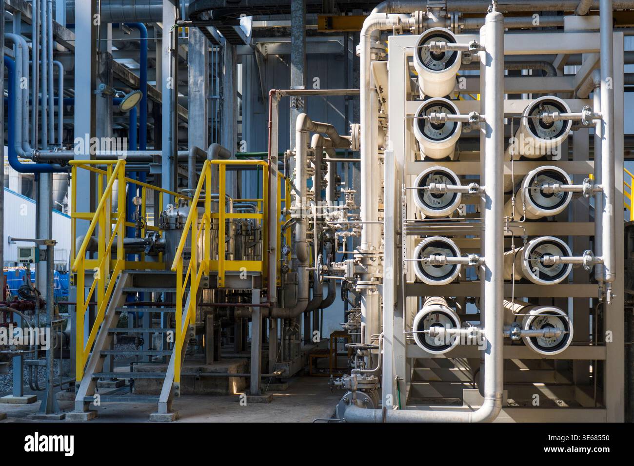 Un'ampia ripresa di un complesso impianto di trattamento delle acque industriali. L'immagine presenta più recipienti a pressione bianchi a membrana per osmosi inversa disposti in Foto Stock