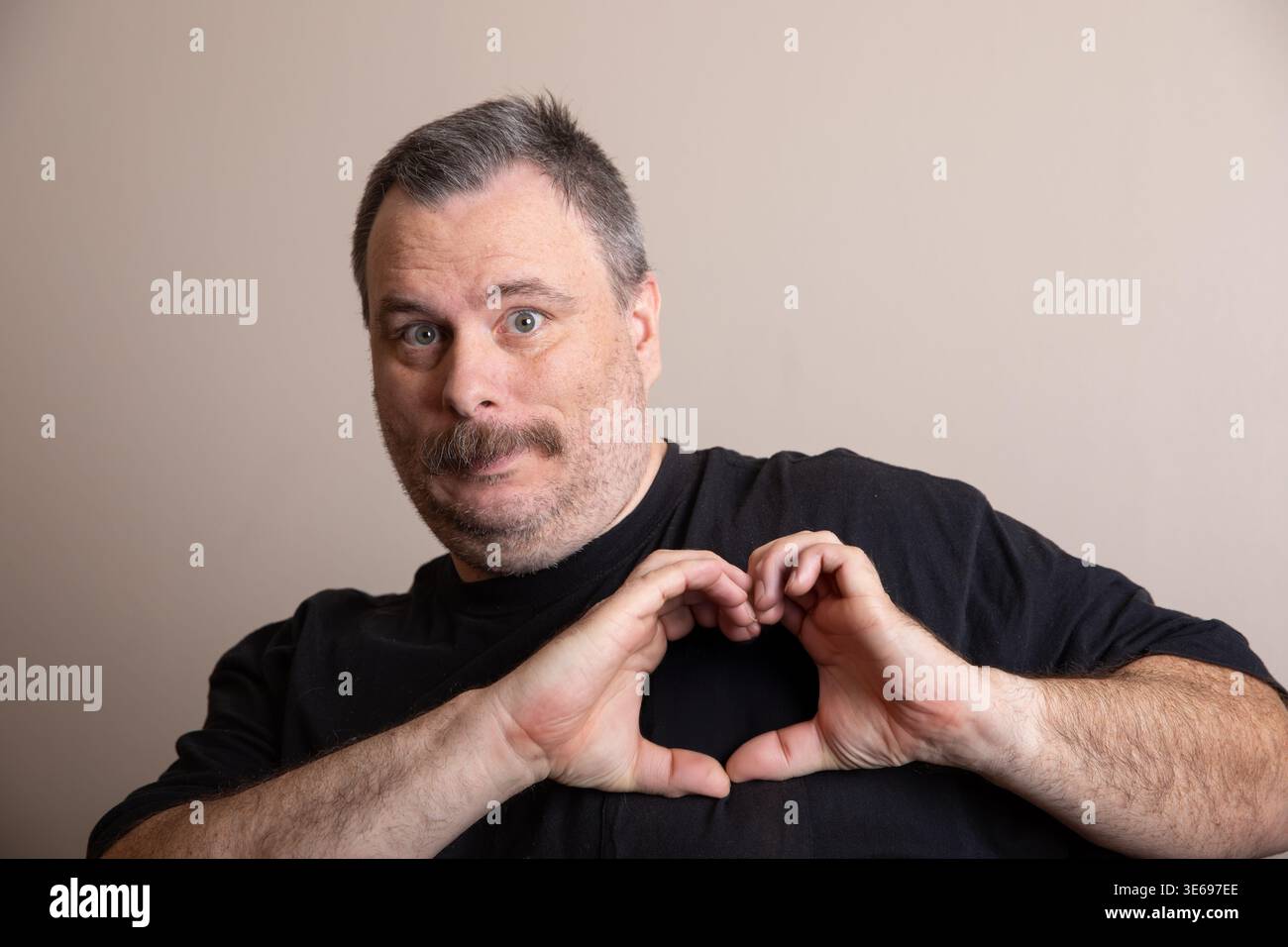Uomo amichevole che forma il simbolo del cuore Foto Stock