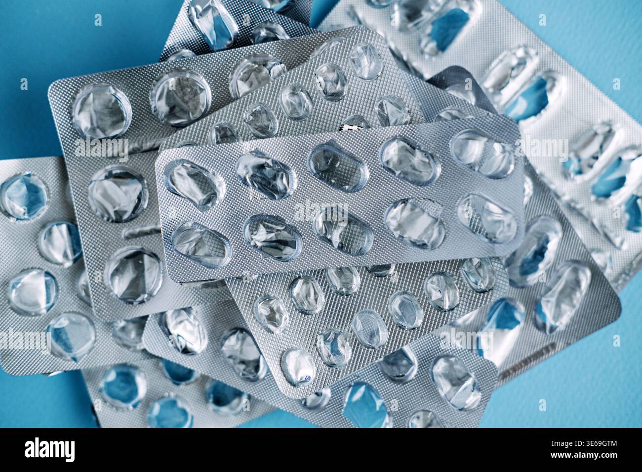 La raccolta delle confezioni blister di farmaci usati è sparsa sulla superficie blu. Rifiuti medici non riciclabili, inquinamento plastico nel settore sanitario, eco Foto Stock