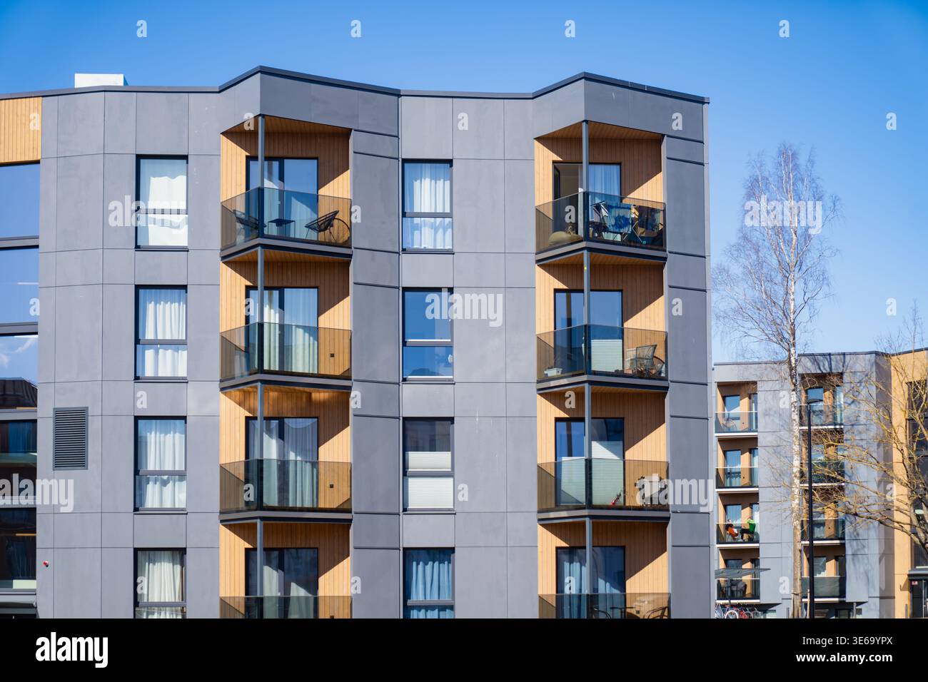 Facciata residenziale contemporanea a Tartu con balconi sovrapposti e grandi finestre, che mostrano fascino immobiliare e domanda di alloggi moderni Foto Stock