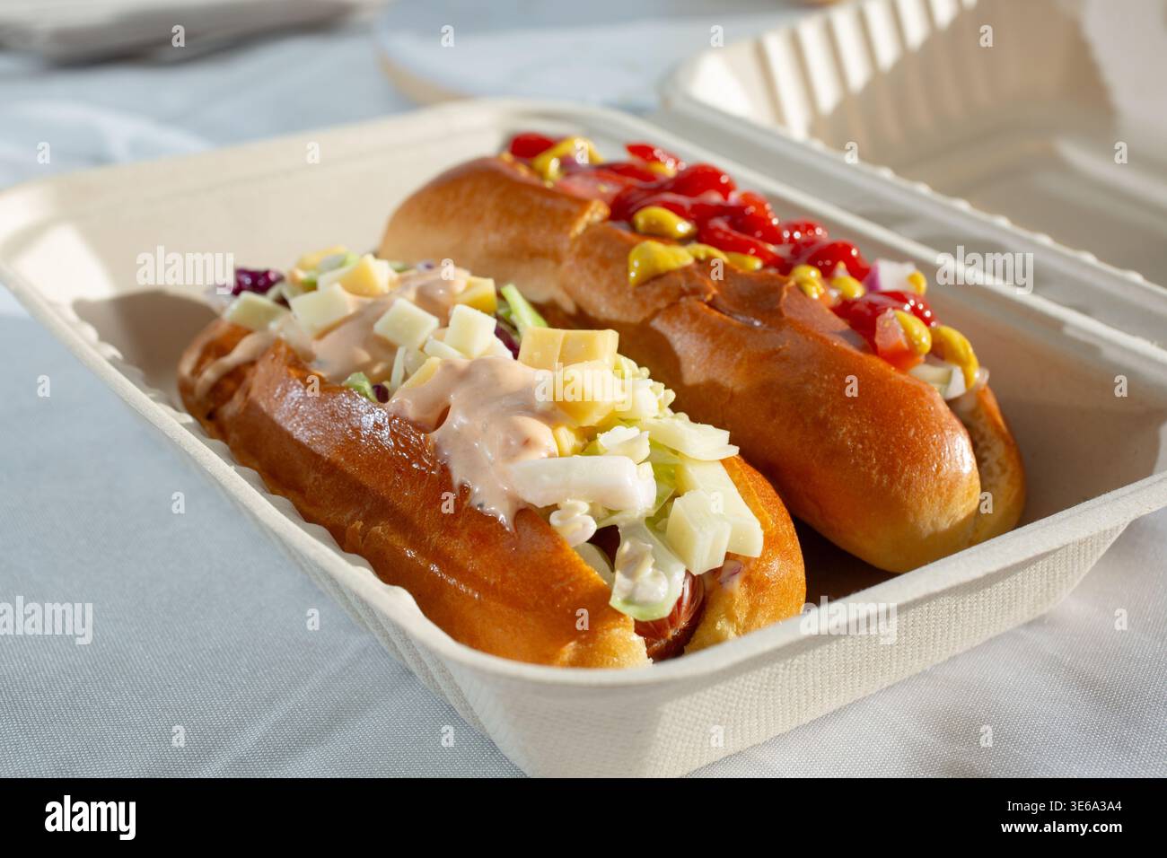 Vista di alcuni hot dog in un contenitore biodegradabile a conchiglia. Foto Stock