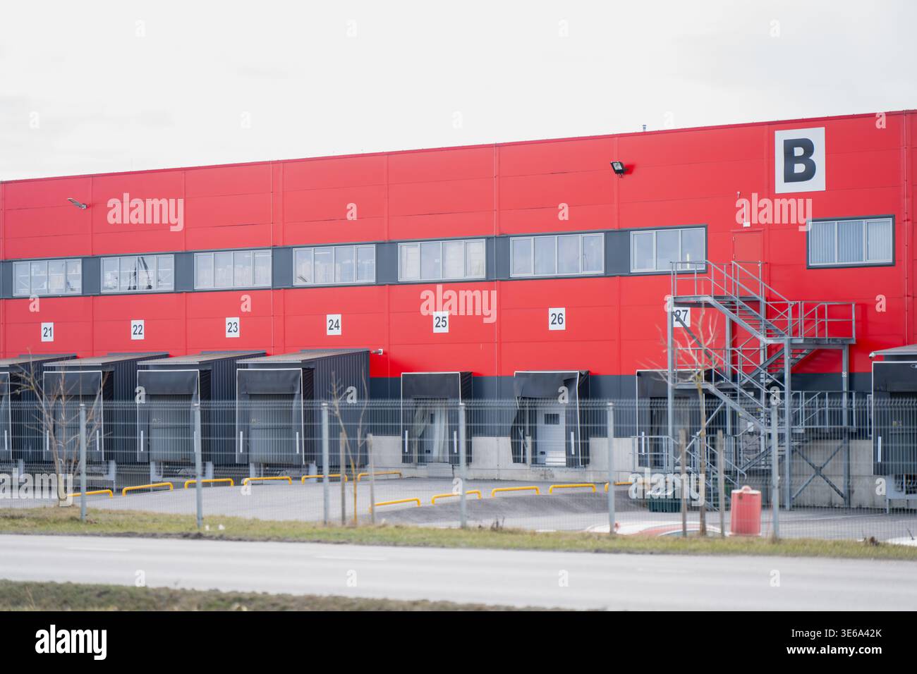 Moderno magazzino di distribuzione con banchine di carico e scale di accesso in metallo che illustrano la movimentazione delle merci, la logistica, la proprietà e le operazioni industriali Foto Stock