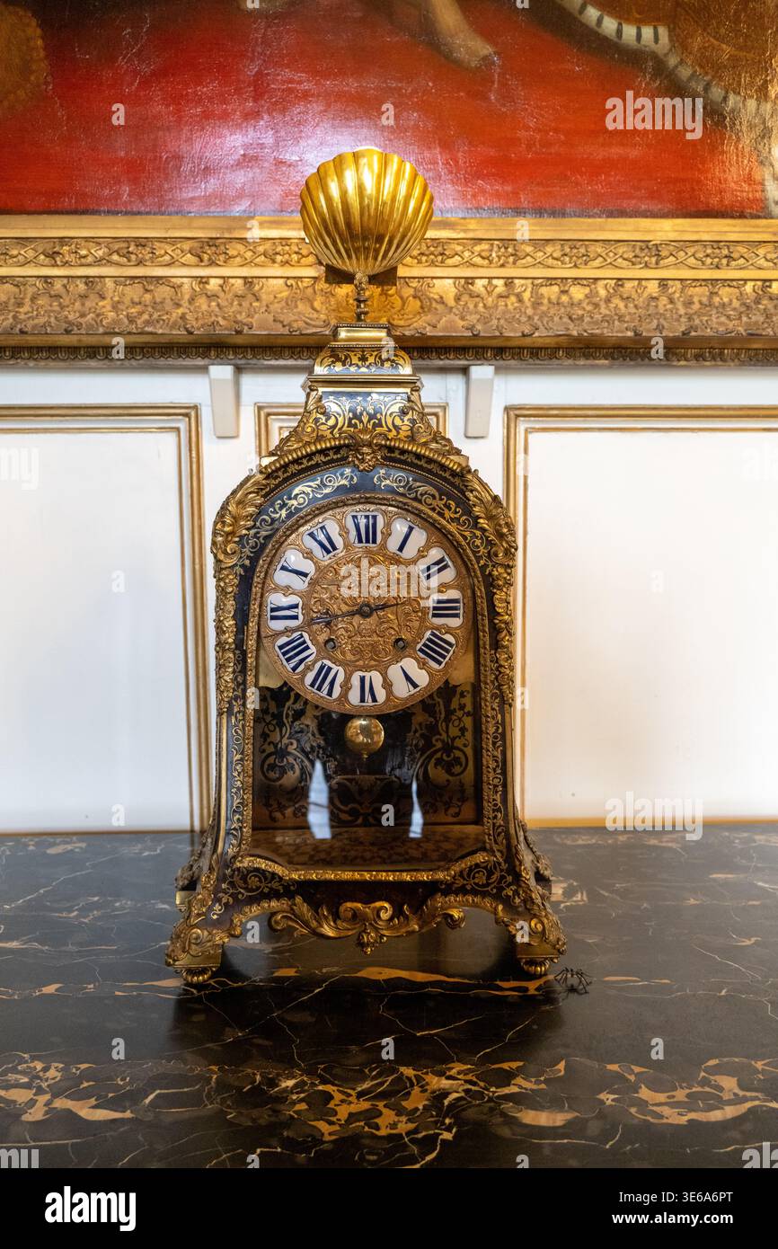Warwick, Regno Unito - 12 aprile 24: Orologio decorativo dorato esposto in una sfarzosa sala del castello di Warwick. Foto Stock