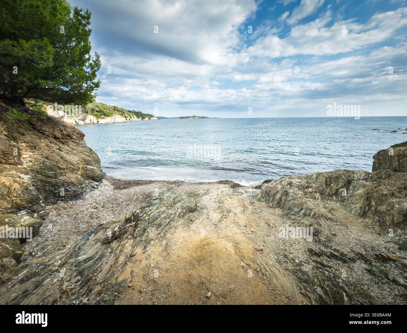 Rocky creek sulla Presqu'ile de Giens a Hyeres, in francia, sul Mar Mediterraneo, con una piccola insenatura, pini e costa frastagliata che riflettono il Foto Stock