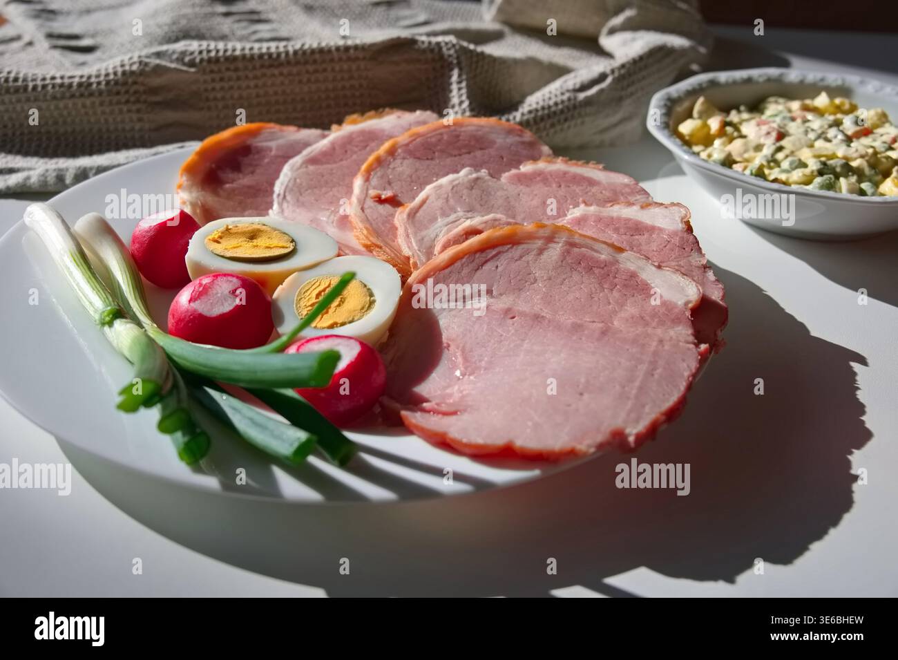 Primo piano di carne trasformata, uova, ravanello e cipolla di primavera sul tavolo Foto Stock