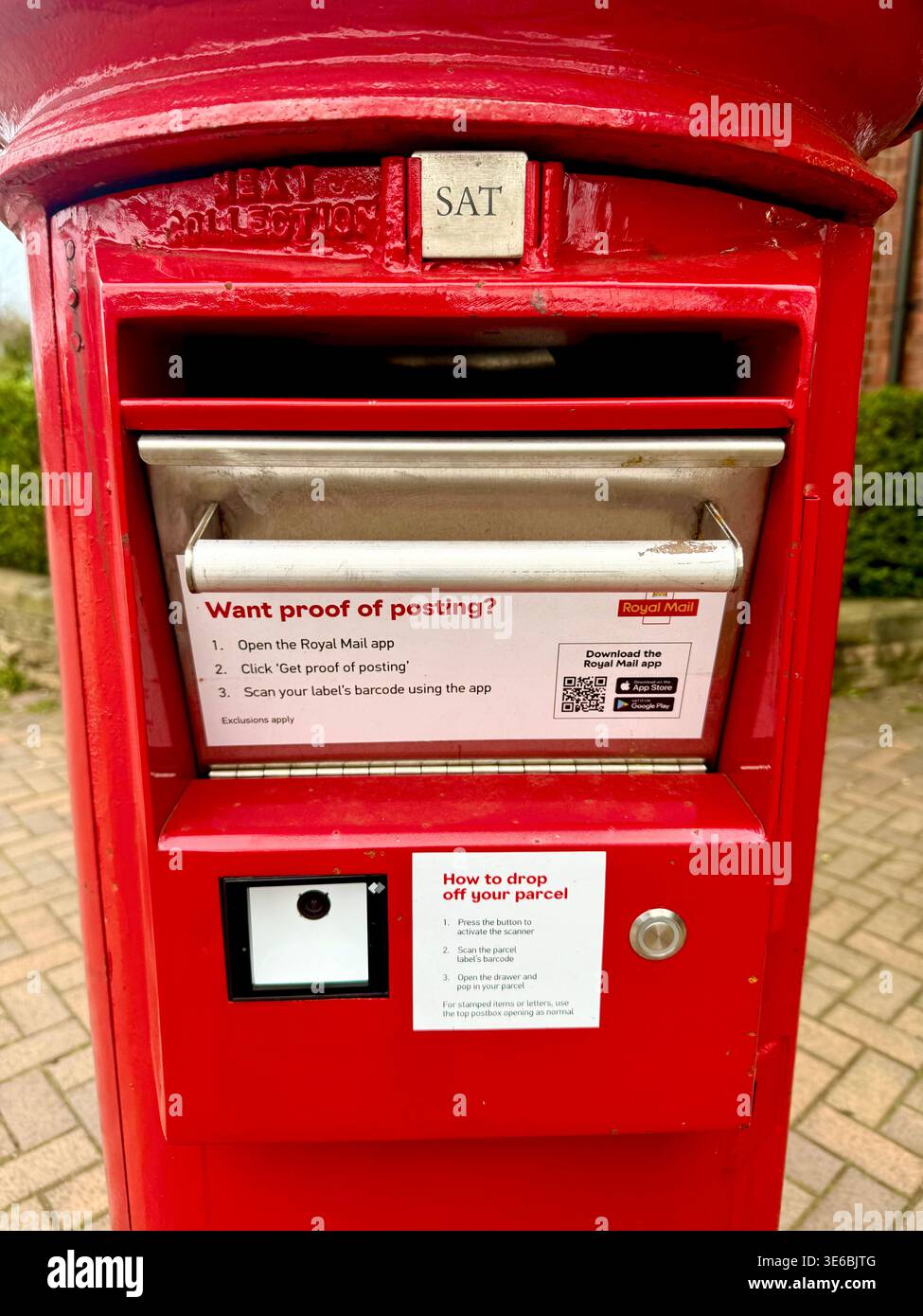 Un pacco e una cassetta postale della Royal mail Foto Stock