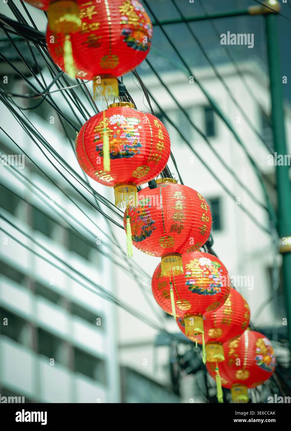 Lanterne cinesi rosse di felicità lungo le linee elettriche a Bangkok Foto Stock