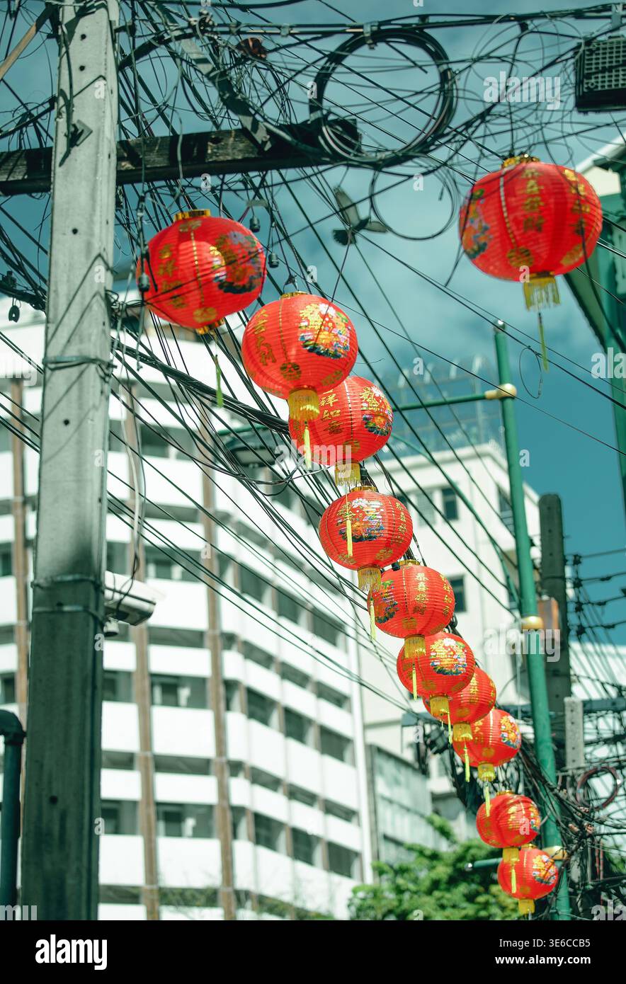 Lanterne cinesi rosse di felicità lungo le linee elettriche a Bangkok Foto Stock