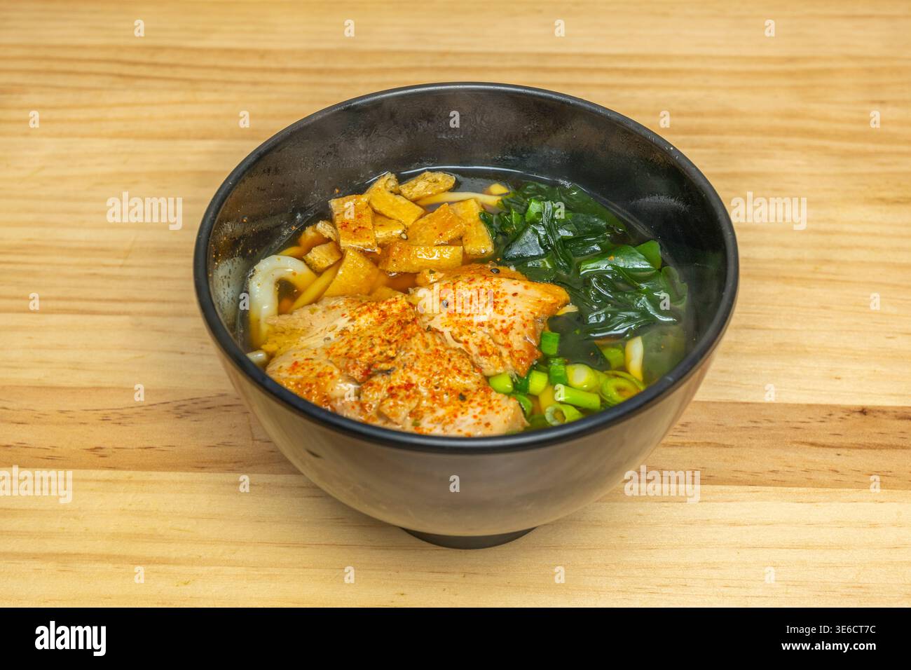 Una ciotola di ramen piccante rosso come il tramonto di Kyoto, con una palla di pasta gochujang che si scioglie lentamente e rilascia aromi che sembrano muoversi all'interno del fot Foto Stock