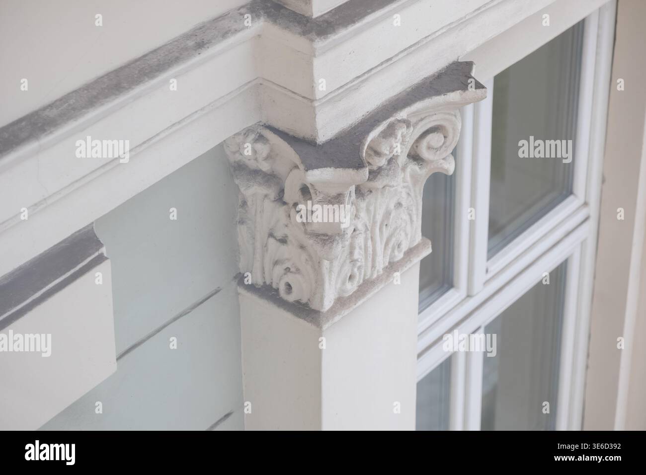 Vista ravvicinata che mostra un capitello decorativo a colonna bianca con intricate incisioni in foglie di acanto, evidenziando lo stile architettonico classico e l'histo Foto Stock