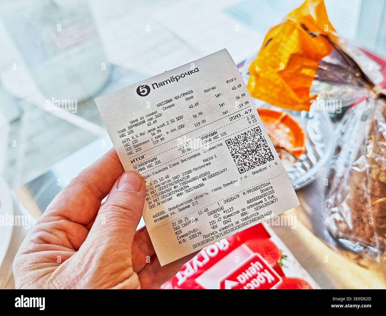 Orenburg, Russia - 22 agosto 2025: Una persona possiede una ricevuta del negozio che mostra gli articoli acquistati e le spese totali di una recente visita di acquisto di generi alimentari. Foto Stock