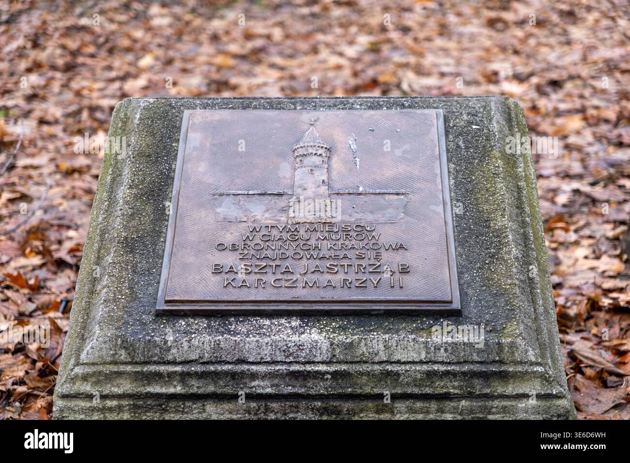 Cracovia, Polonia - 2 dicembre 2025: Lapide di monumento intemprata, rilievo in bronzo mostra l'arte della torre e testo polacco sulla storica torre di Jastrzab Karczmarzy Foto Stock
