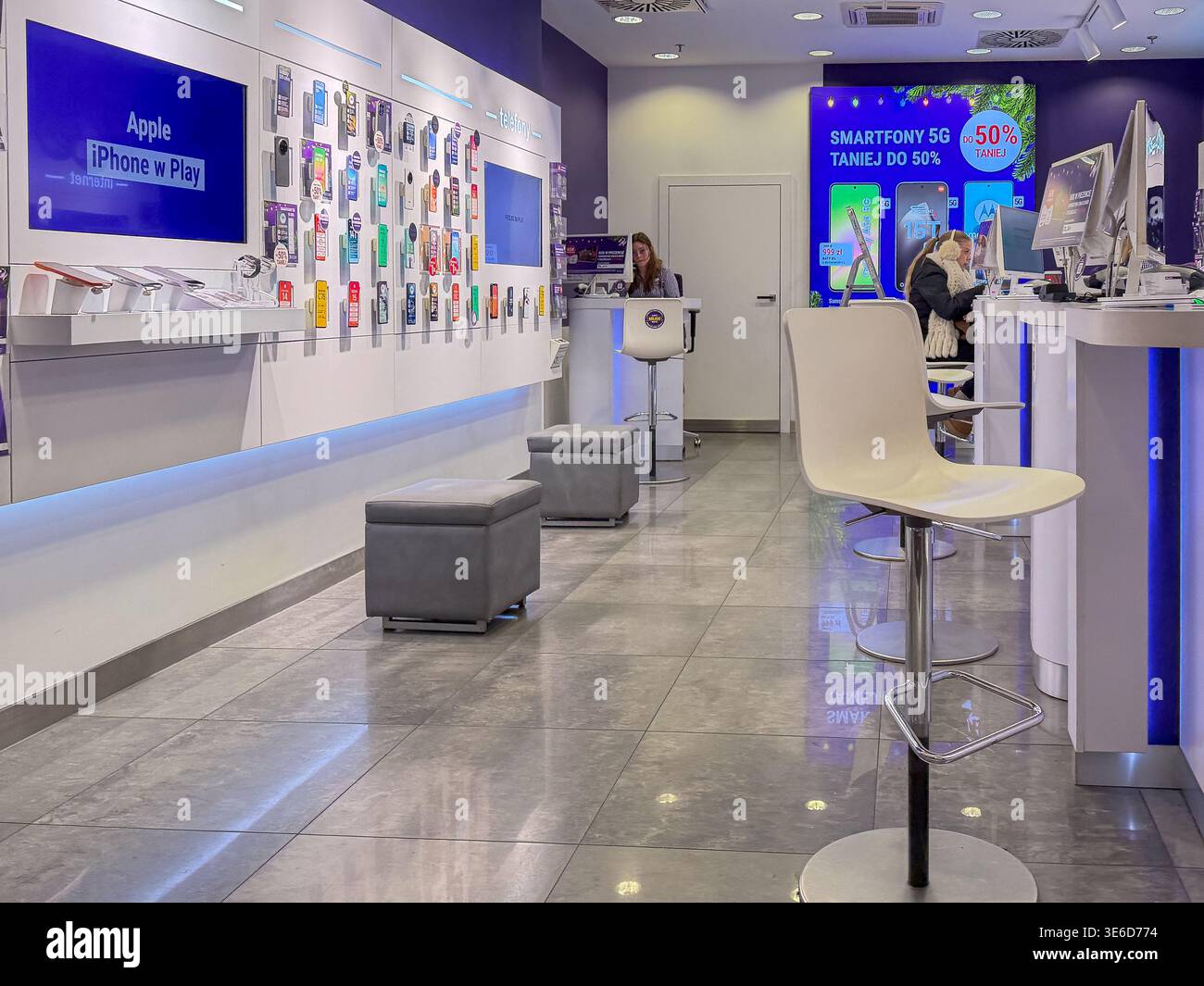 Cracovia, Polonia - 2 dicembre 2025: Il negozio di telecomunicazioni Modern Play offre prodotti Apple iPhone, accessori per smartphone diversi e clienti Foto Stock
