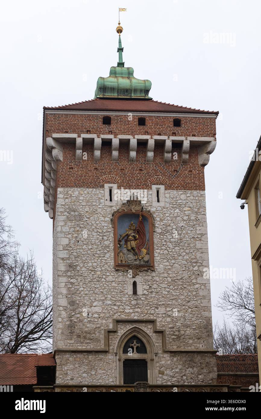 Cracovia, Polonia - 1° dicembre 2025: Porta di San Floriano a Cracovia con mura medievali in pietra, accenti in mattoni e l'iconico rilievo di San Floriano, il repre Foto Stock