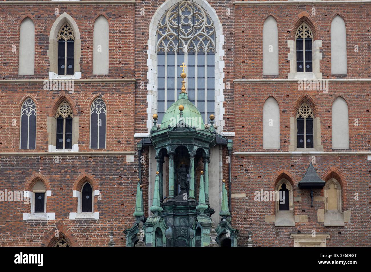 Cracovia, Polonia - 1 dicembre 2025: Dettagli architettonici della basilica di Santa Maria rivelano la sua cupola verde in rame, intricate finestre gotiche e intemperie Foto Stock