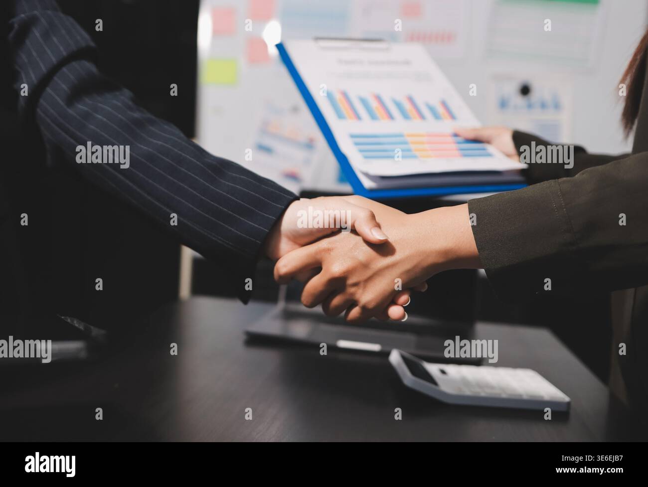 I giovani uomini d'affari scuotono le mani in ufficio. Conclusione di una riunione di successo. Tre persone. Schermo panoramico Foto Stock