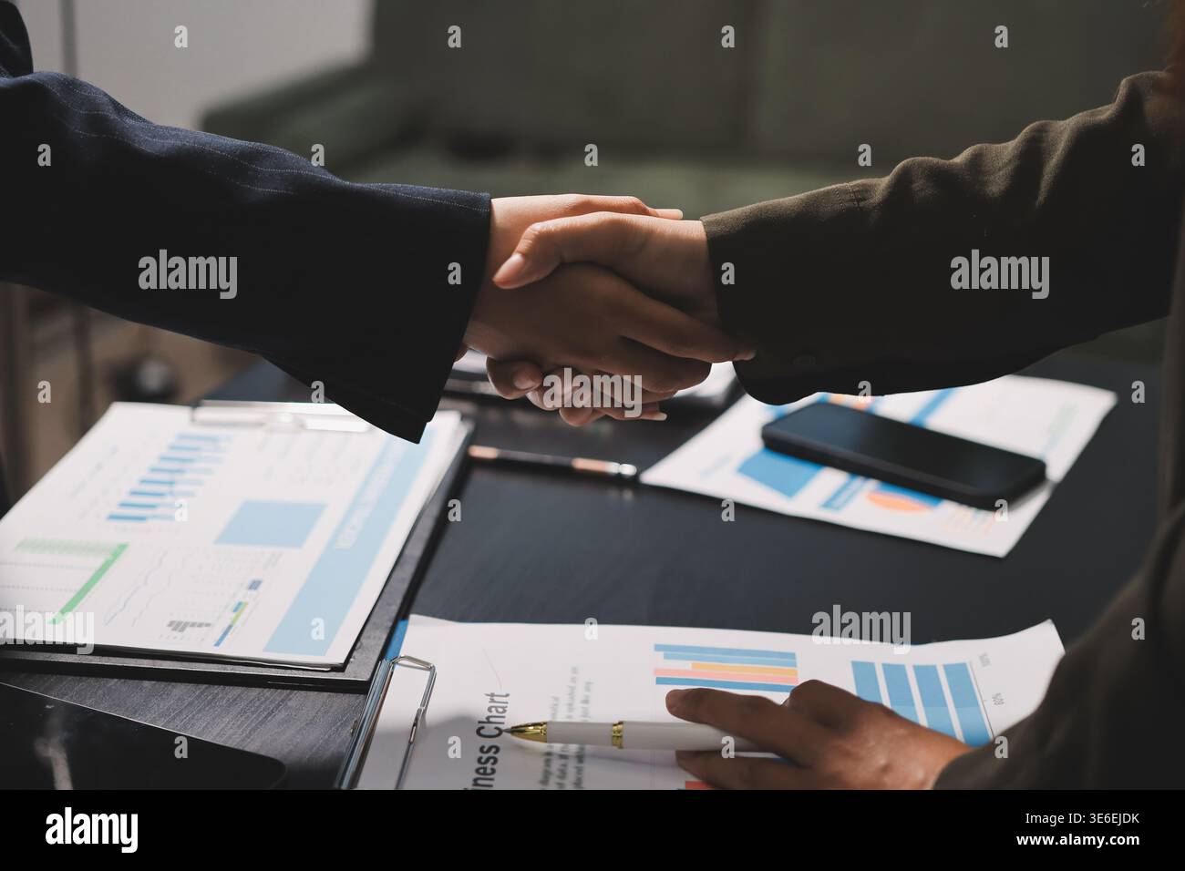I giovani uomini d'affari scuotono le mani in ufficio. Conclusione di una riunione di successo. Tre persone. Schermo panoramico Foto Stock