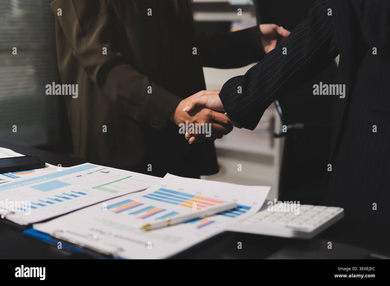 I giovani uomini d'affari scuotono le mani in ufficio. Conclusione di una riunione di successo. Tre persone. Schermo panoramico Foto Stock