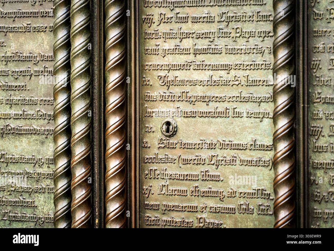 Primo piano di antiche placche in metallo incise con colonne decorative ritorte e testo gotico, patina intemprata e trama storica, ideale come ba Foto Stock