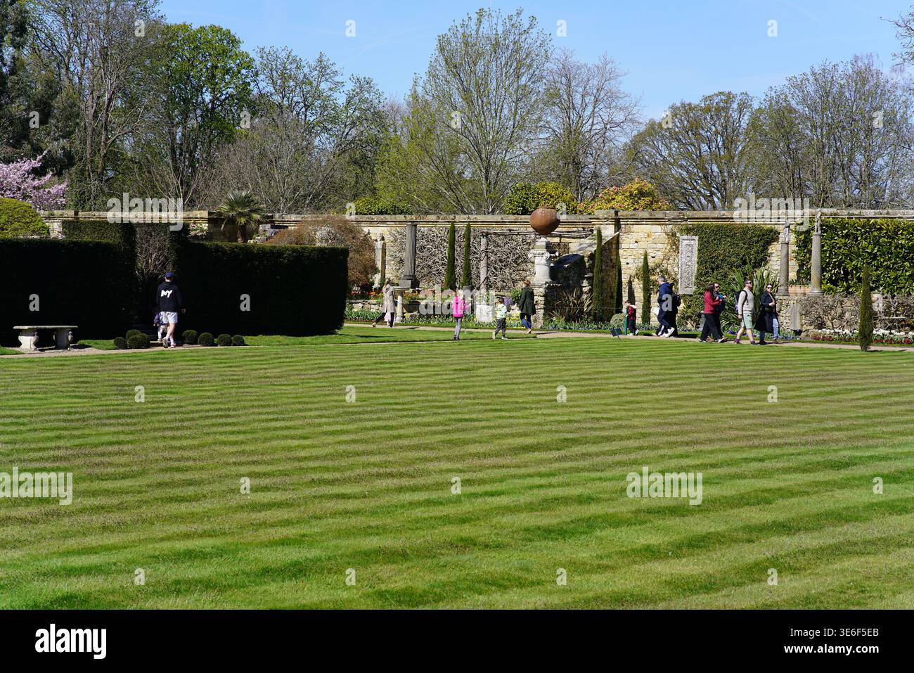 Prato curato e a righe con visitatori agli Hever Castle Gardens in una giornata di primavera assolata nel Kent, Inghilterra. Hever Castle, Hever, Inghilterra Foto Stock