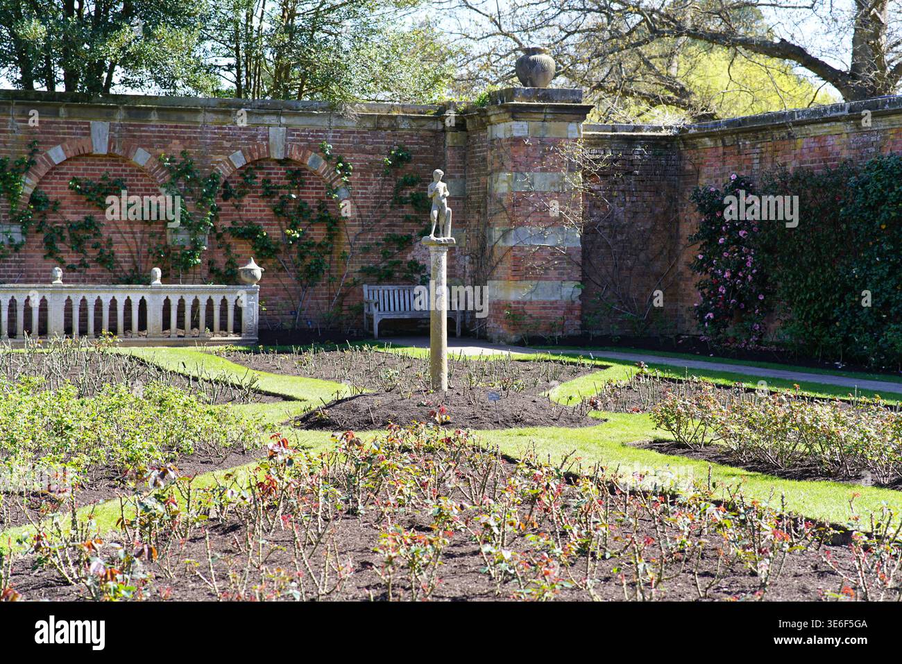 Giardino primaverile formale con statua e letto di rose presso gli Hever Castle Gardens, giornata di sole nel Kent, Inghilterra. Hever Castle, Hever, Inghilterra Foto Stock