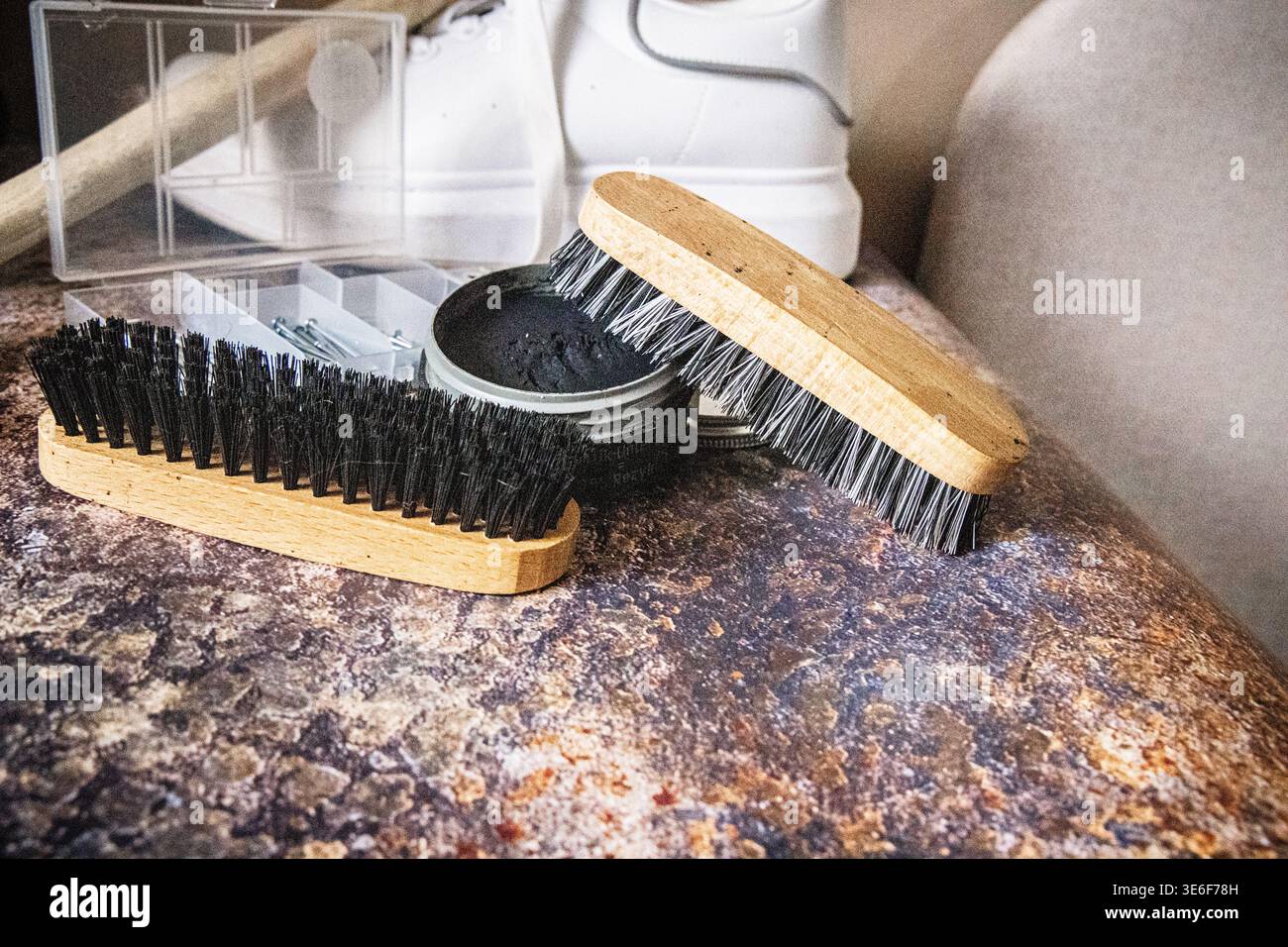 Sneaker bianca con spazzole per scarpe e accessori per la pulizia Foto Stock