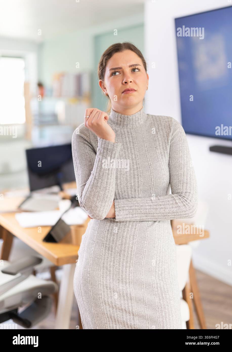 Giovane donna triste mentre lavora in ufficio Foto Stock