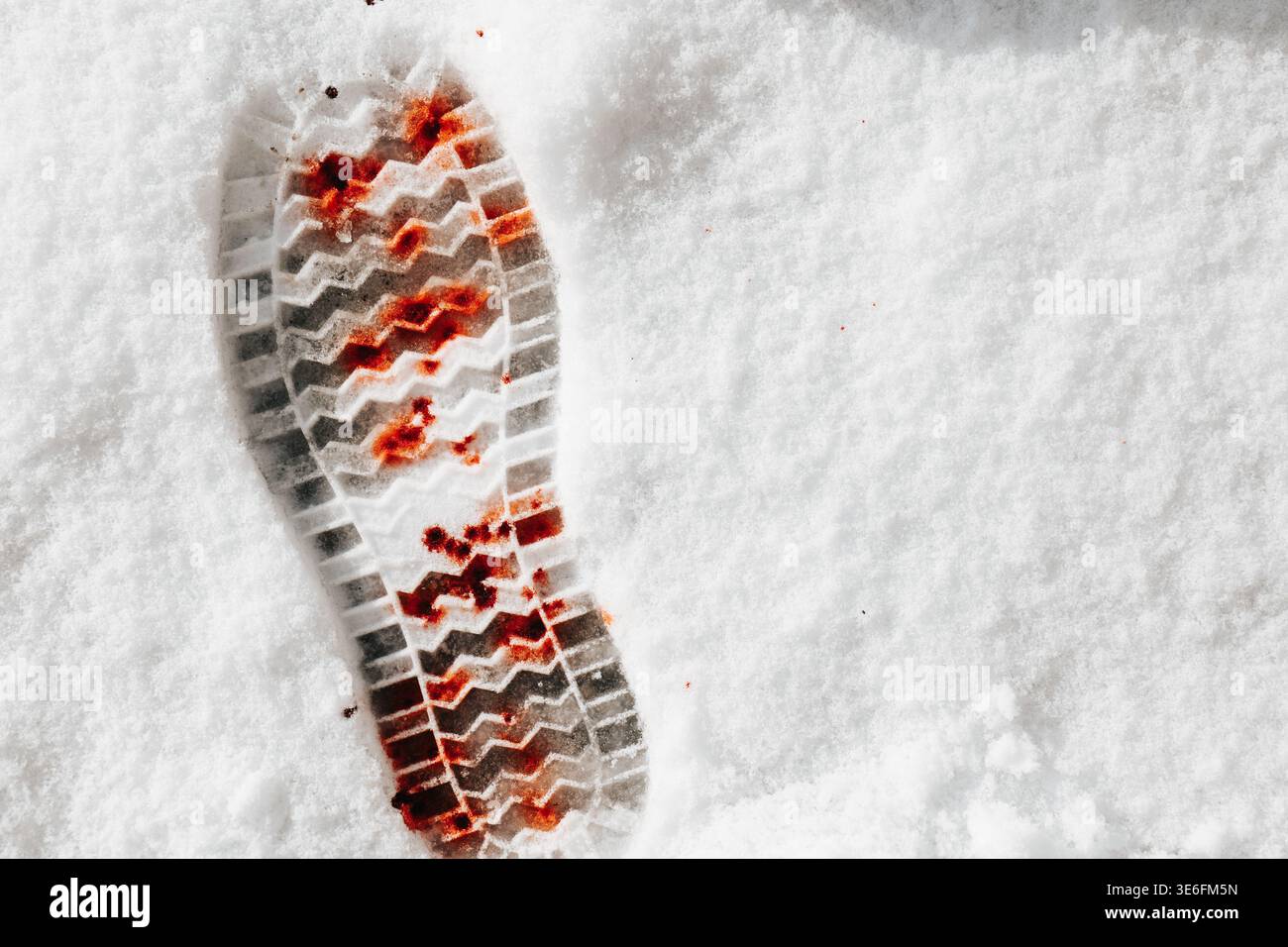 stampa scarpe sulla neve con macchie rosse e ampio spazio per le copie. Pubblicazioni sul crimine, storie investigative, copertine di libri. Immagine concettuale della scena del crimine Foto Stock