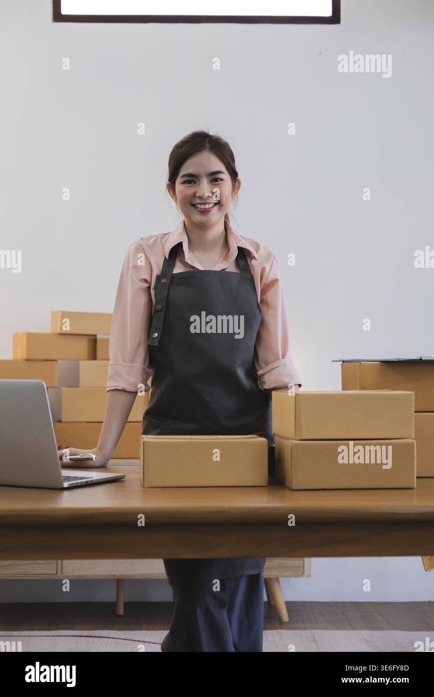 Ritratto di giovane donna asiatica PMI che lavora con una scatola a casa il workplace.start-up piccolo imprenditore di impresa, piccole imprese imprenditore PMI o freelance Foto Stock