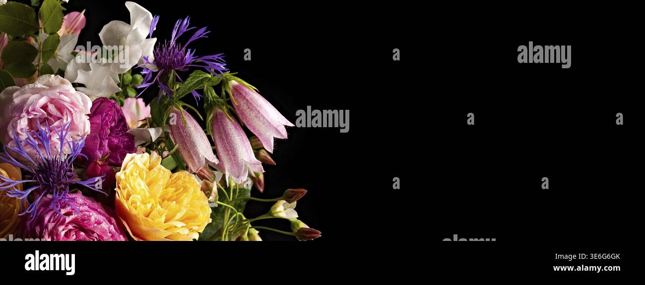 Colorata disposizione floreale su sfondo nero: Rose, gigli e fiori selvatici in contrasto incredibile Foto Stock