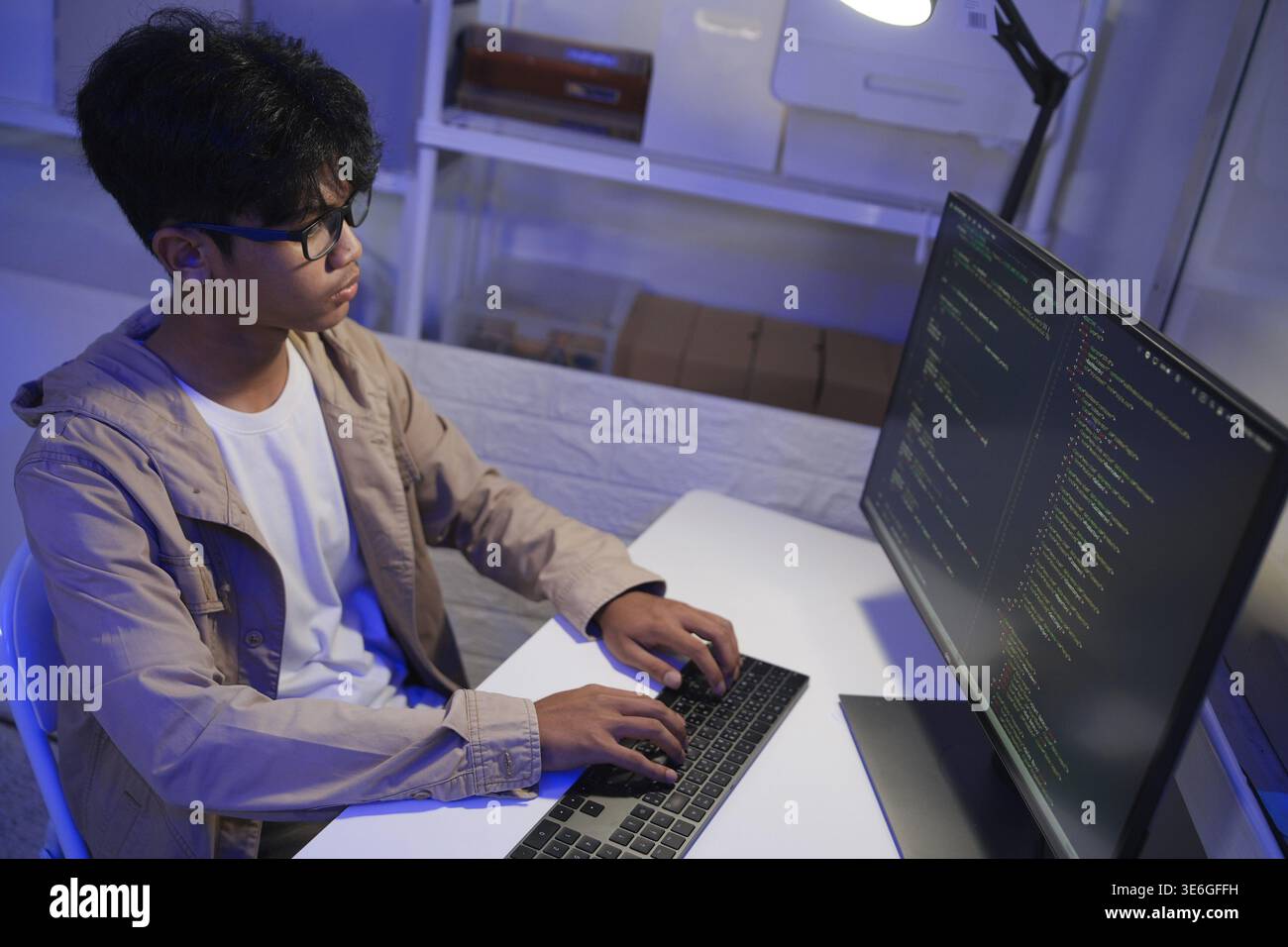 Software Engineer maschio che scrive codice su computer desktop con configurazione a più schermi. Programmatore di data center che gestisce grandi set di dati utilizzati nella formazione ai Foto Stock