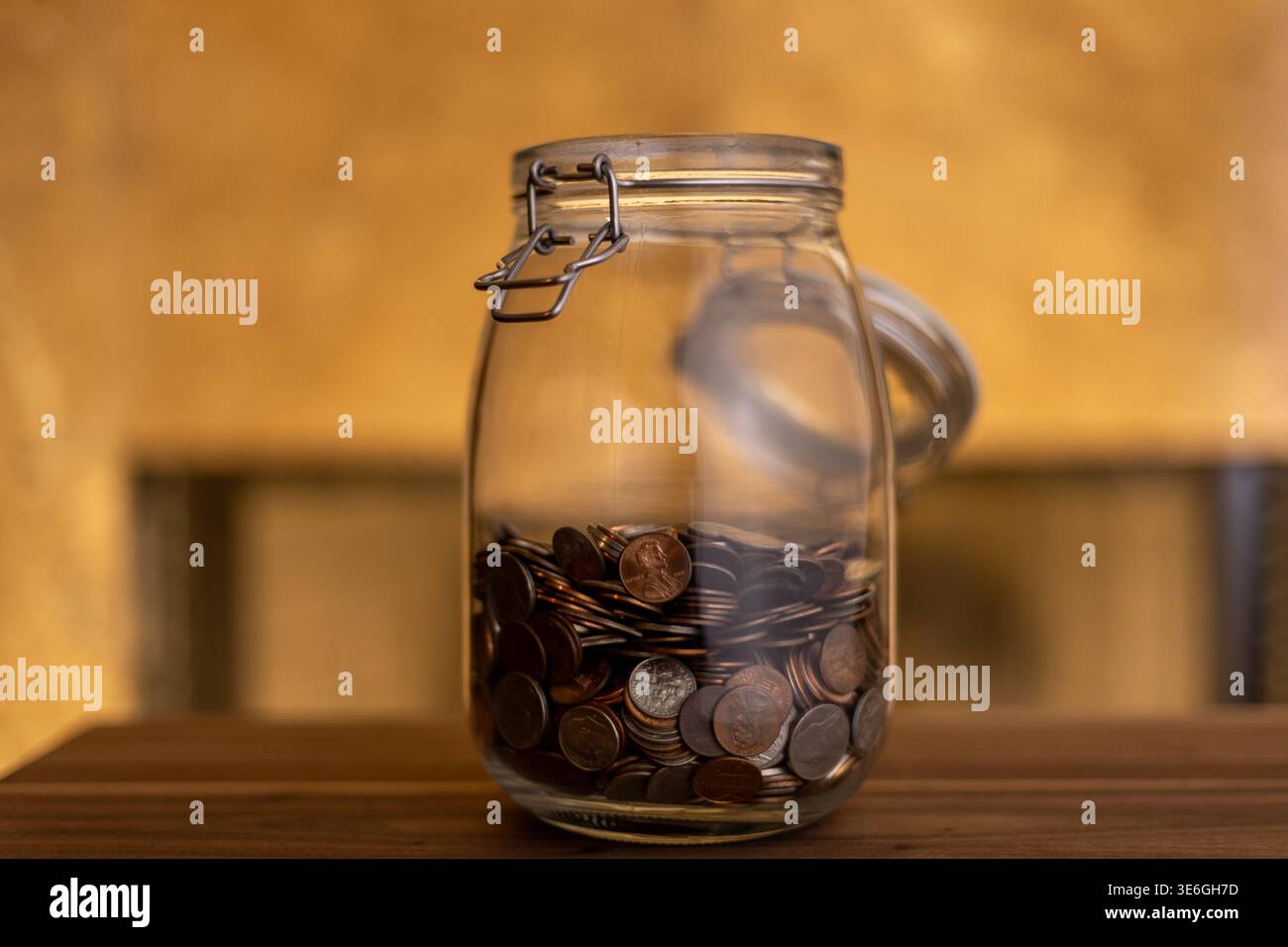 Monete in vaso aperto per muratori con illuminazione calda: Risparmio e budget Foto Stock