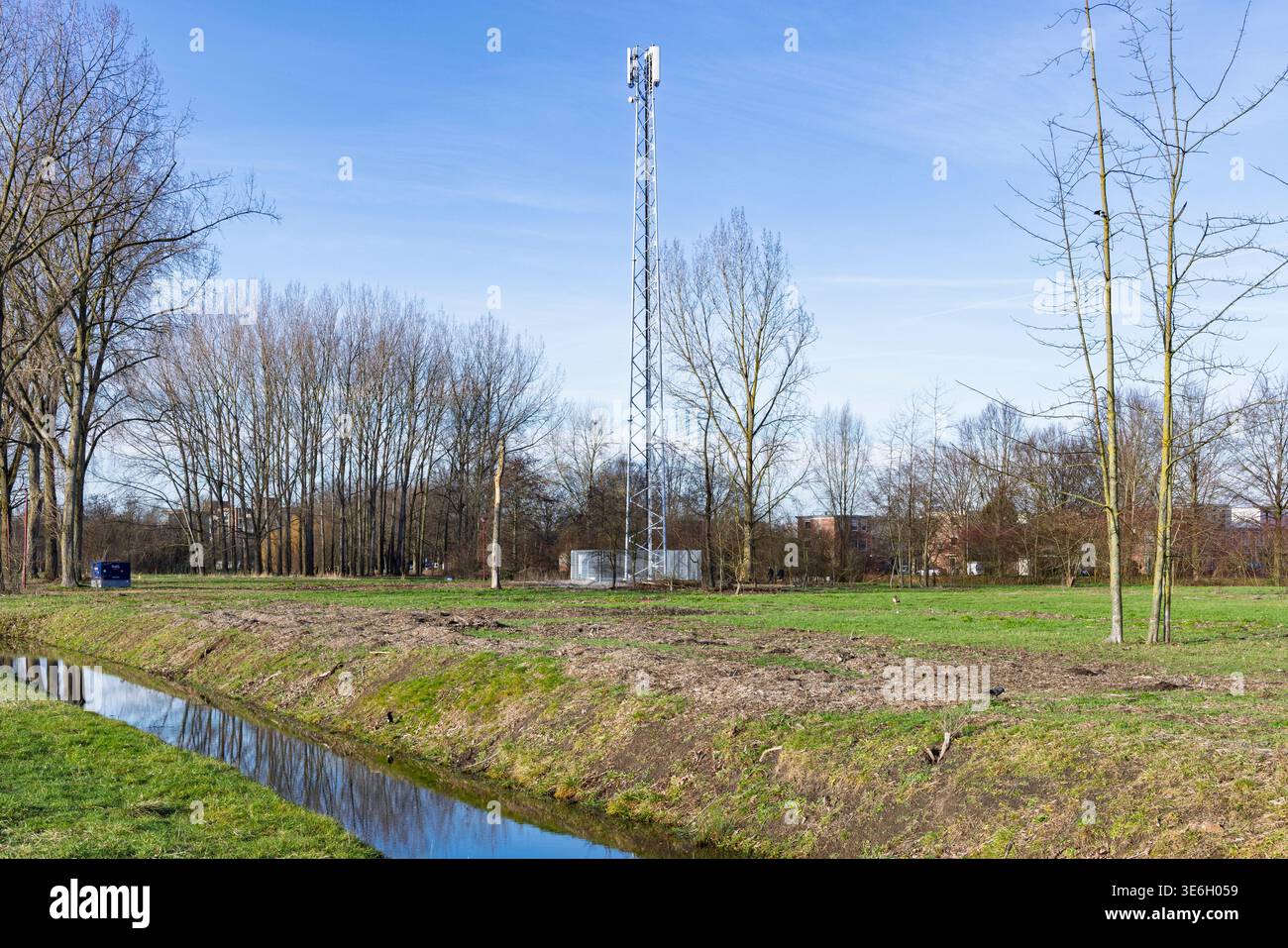 Paesi Bassi, 17 gennaio 2026. Un albero di telecomunicazione in acciaio a reticolo alto per segnali 4G e 5G situato in un campo vicino a fossati e alberi. Foto Stock