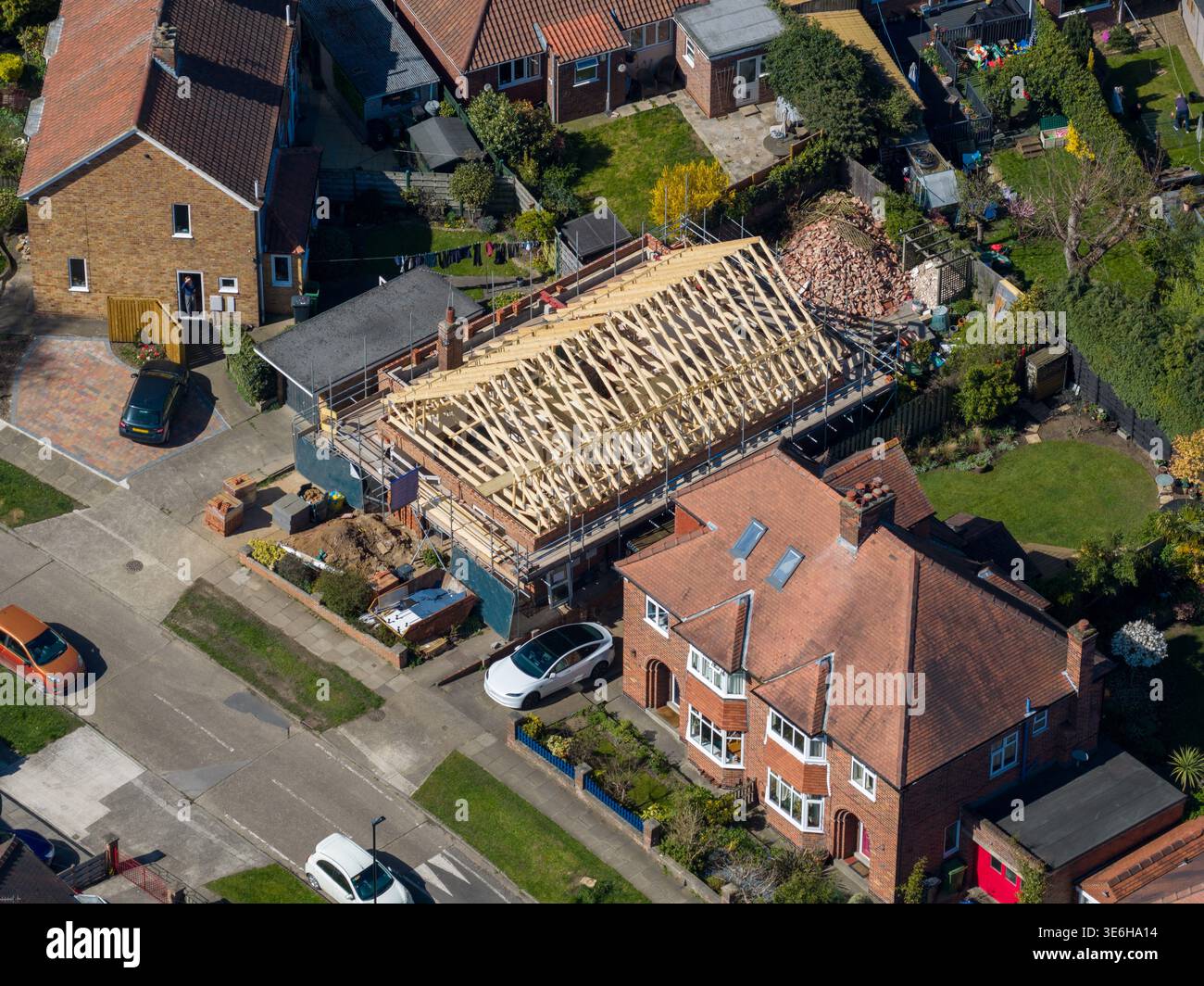 Veduta aerea della costruzione di case nella città di York nel Regno Unito, che mostra l'impalcatura del telaio del tetto in legno e i materiali da costruzione all'interno di un neig residenziale Foto Stock