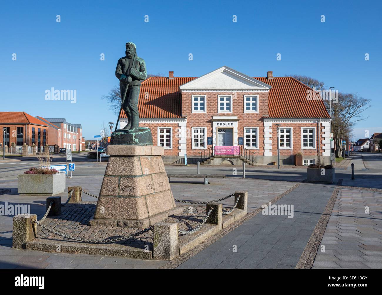 Ringkøbing, Danimarca - 19 marzo 2026: Il museo di storia locale con una statua dell'esploratore polare nato localmente Mylius Erichsen di fronte Foto Stock