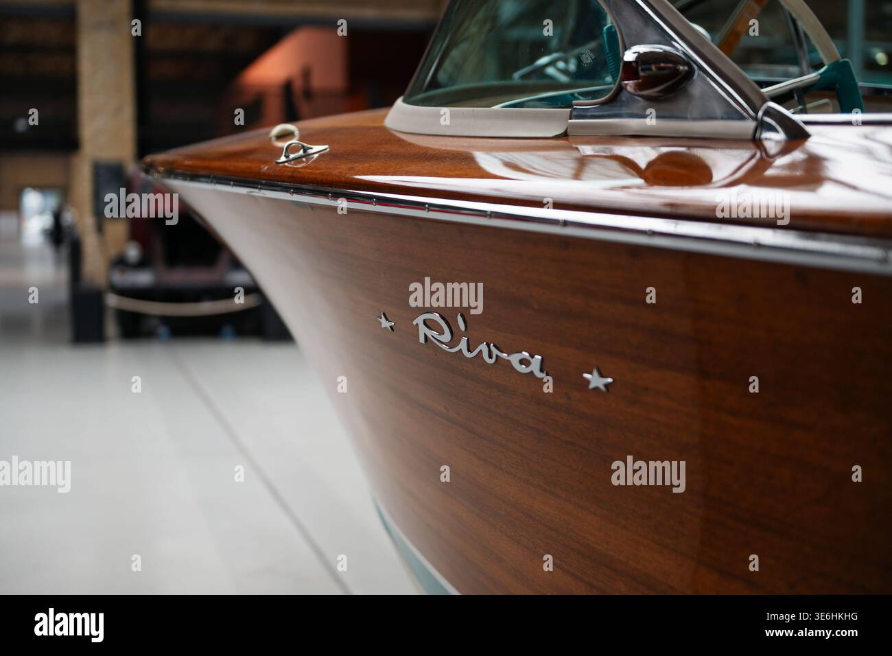 Classico scafo in legno Riva con logo cromato. Foto ravvicinata di un motoscafo Riva vintage in Boathouse: Finitura in legno lucido e emblema Riva cromato Foto Stock