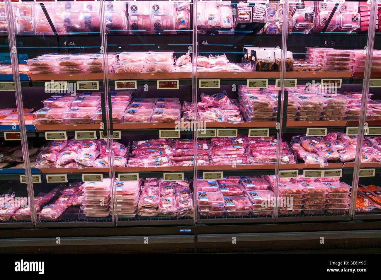 RIGA, LETTONIA. 12 marzo 2026. Espositori refrigerati pieni di carne cruda confezionata in un supermercato moderno: Ampia vista su un negozio di alimentari Foto Stock