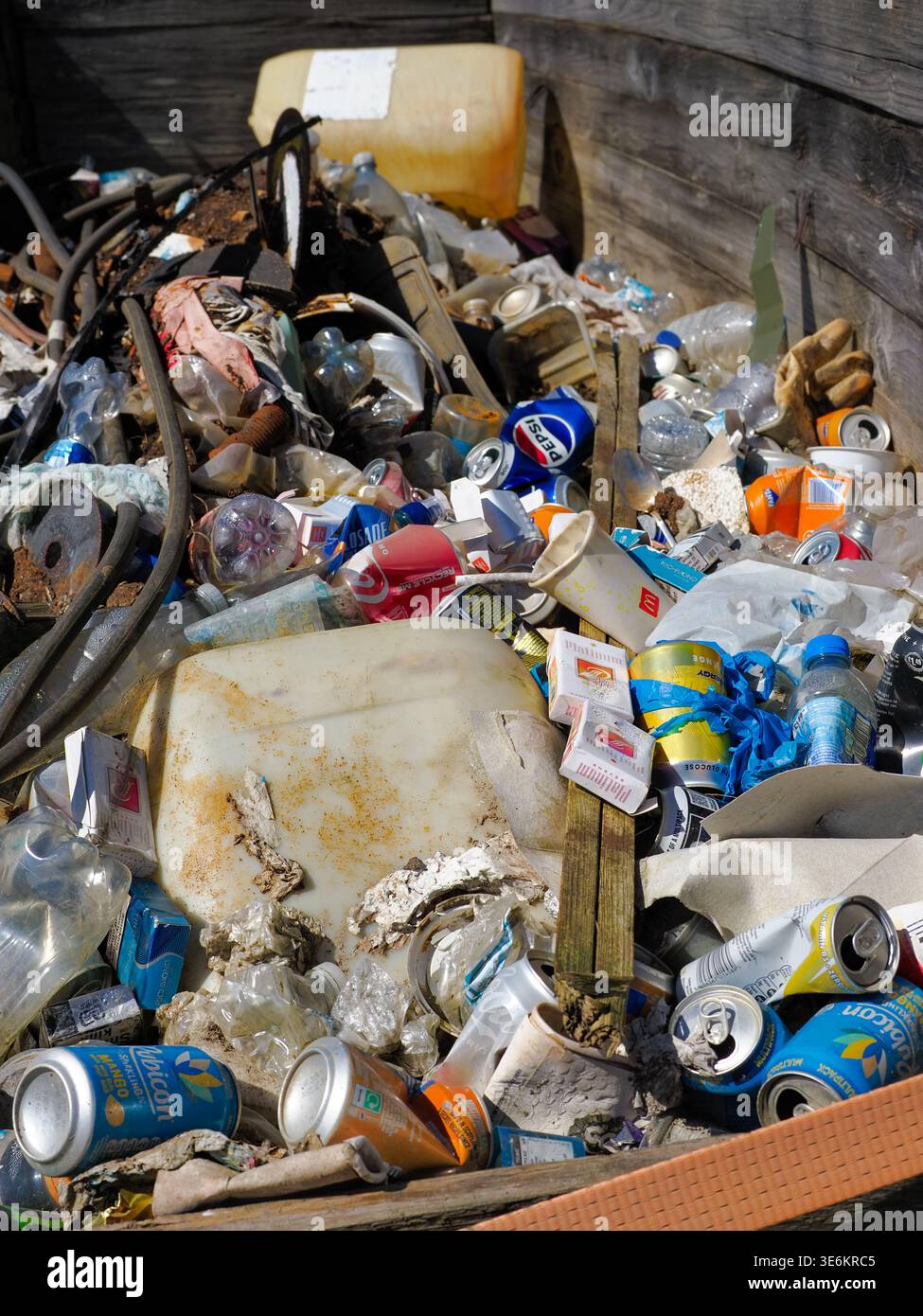 Horwich, Bolton, Regno Unito, 06 aprile 2026: Pile miste di bottiglie di plastica, lattine di alluminio e altri rifiuti scartati accumulati all'aperto, evidenziando l'inquinamento, non Foto Stock