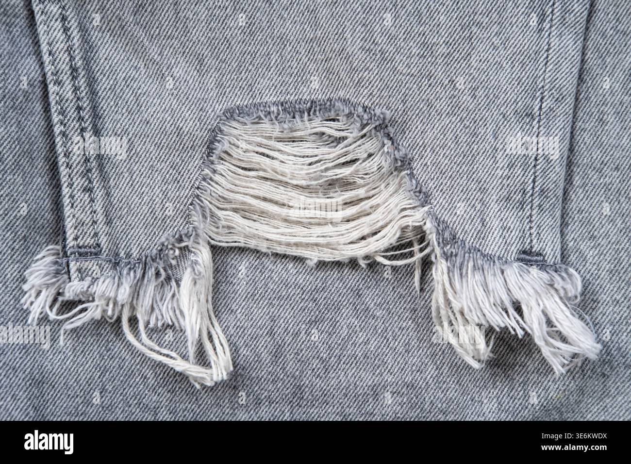 Jeans strappati in tessuto grigio. Foto Stock