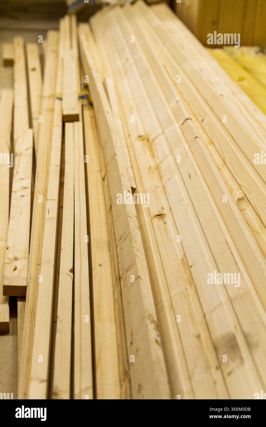 L'immagine mostra una pila di tavole di legno di dimensioni grezze, probabilmente destinate a progetti di costruzione o carpenteria. Foto Stock