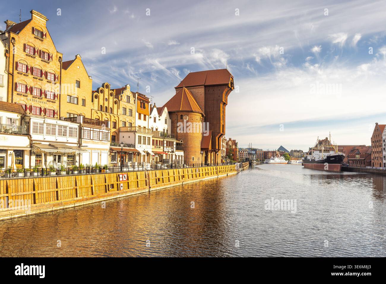 Danzica, Polonia - 2 maggio 2025: Centro storico della città con gru portuale medievale sul fiume Motlawa. Pittoresco canale con edifici storici e. Foto Stock